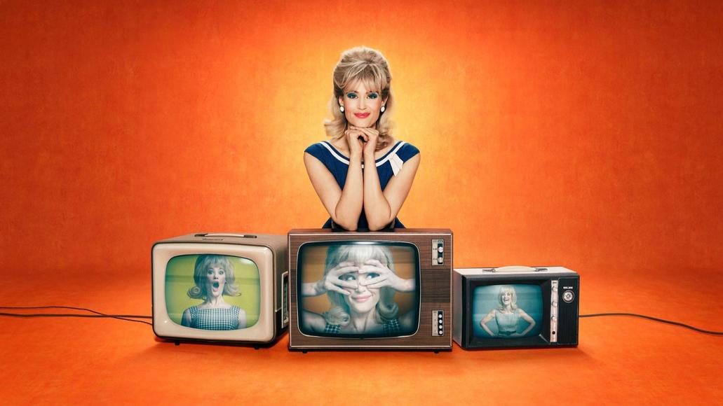 woman kneeling behind three tvs